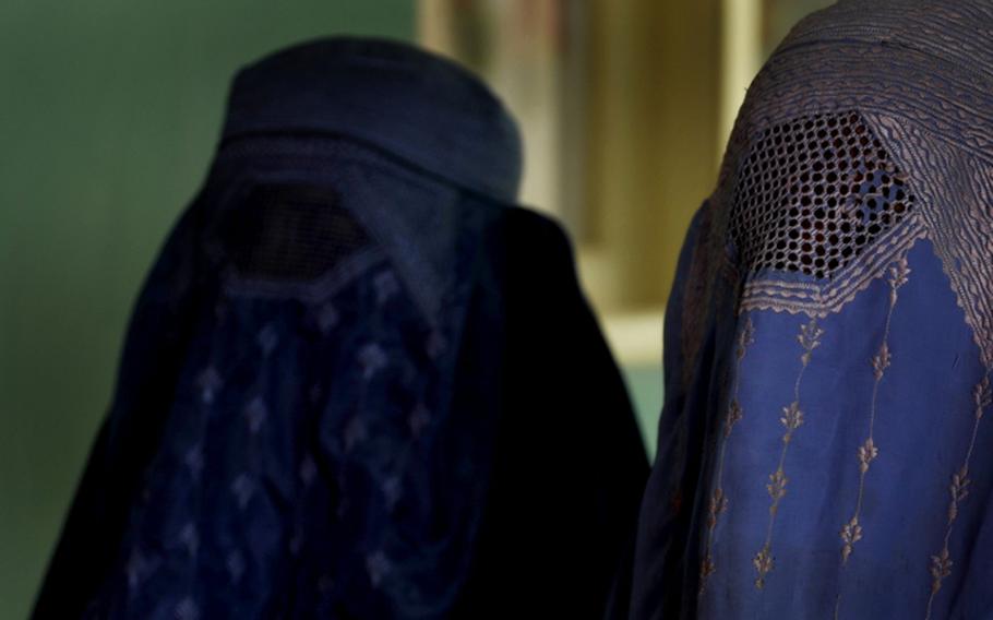 Two Afghan women, members of the Afghan National Police Department, walk down the hall of the Women's Affair building in Zabul Province, Oct. 28, 2009.