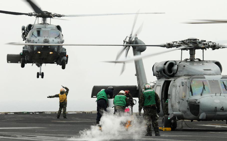 A U.S. Navy SH-60B Sea Hawk helicopter prepares to land on the flight deck of the aircraft carrier USS Ronald Reagan in the Pacific Ocean March 21, 2011, during Operation Tomodachi.