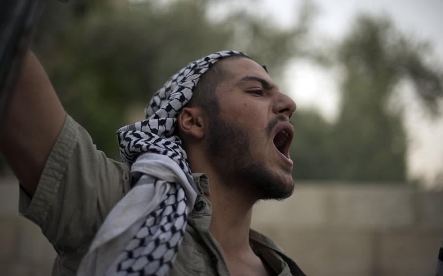 A rebel fighter gives a victory cry after capturing a government position in Al Tal, Syria, July 19, 2012.