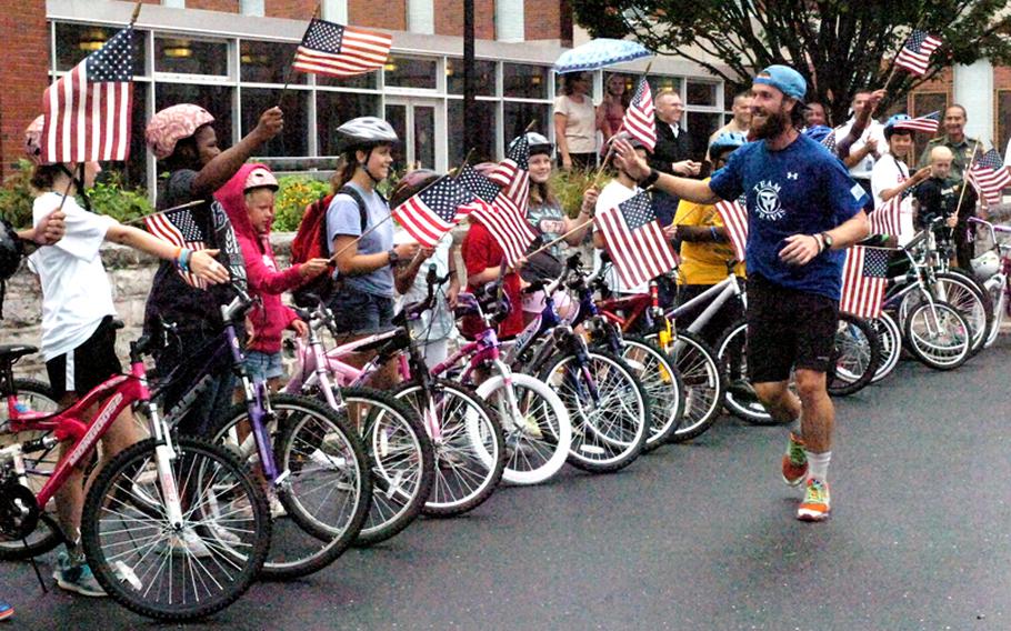 Cyclists greet Albie Masland as he passes through his hometown of Carlisle, Pa., near the end of his cross-country run on August 10, 2012.