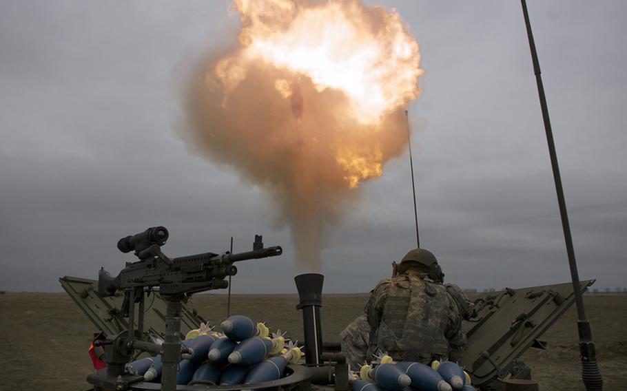 U.S. soldiers cover their ears as a long-range training round is fired out of a 120 mm mortar during live-fire training in Romania in October 2009.