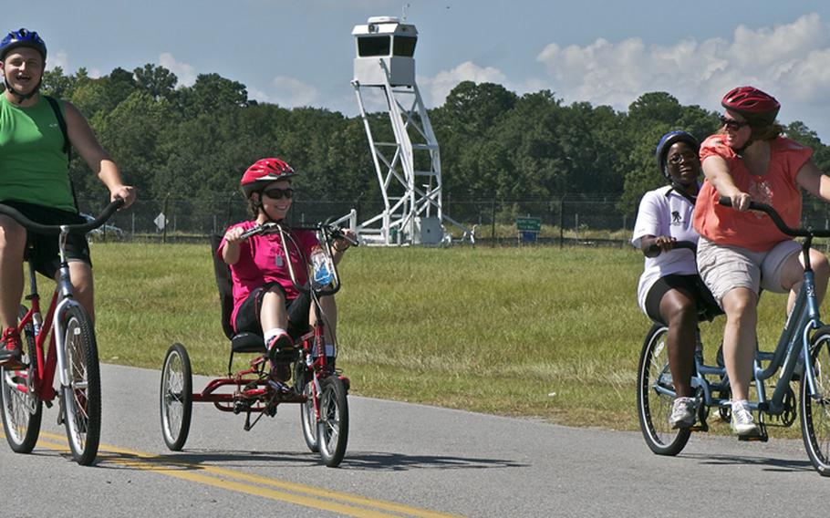 Leeanna Henson, caregiver John Furgeson and two other caregivers on a tandem bike take part in a bike ride during Lt. Dan Weekend on Sept. 15 at Beaufort, S.C.