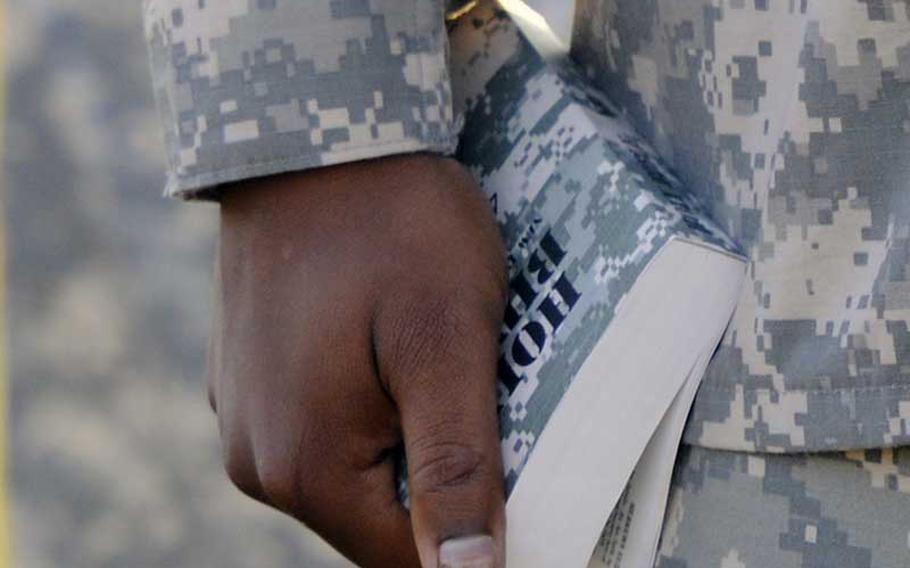 Bible in hand, a chaplain for the Mississippi Army National Guard, conducts chapel service in the field Sunday morning during the unit's annual training at Camp Shelby Joint Forces Training Center in August 2012.