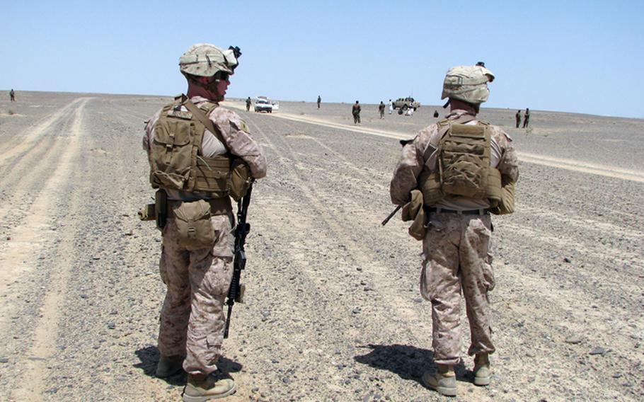 U.S. Marines hang back and observe as Afghan National Army soldiers question the occupants of a car stopped at a checkpoint just outside Camp Dwyer in southern Helmand Province in Afghanistan. Security patrols around the base are one of the few tasks that put Marines "outside the wire" these days, now that the Afghans have taken the lead in security across much of the country.