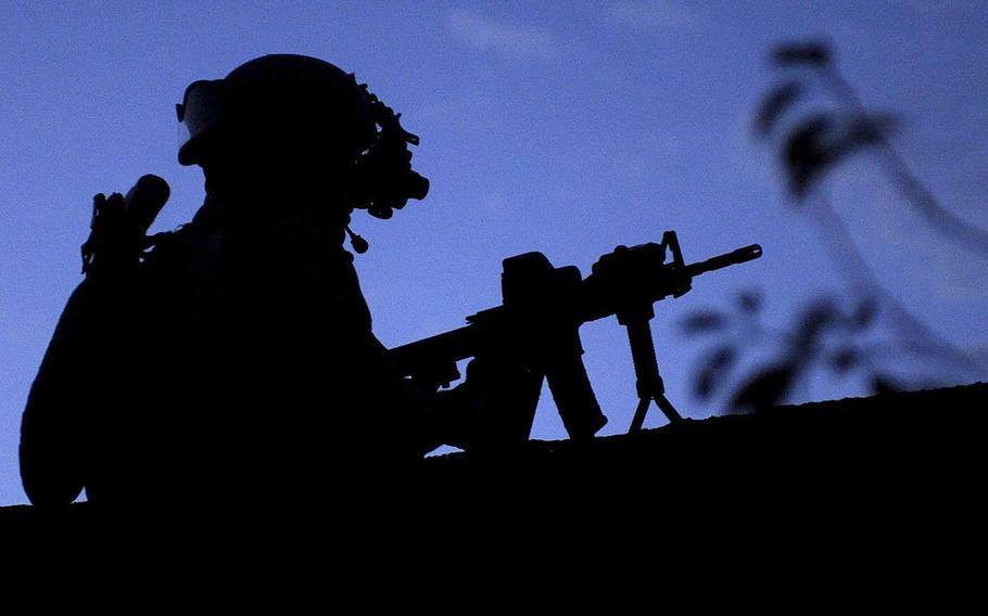 A member of an Afghan-International Security Force is silhouetted against the early morning sky during an operation in Afghanistan's Wardak province on Oct. 4, 2009.
