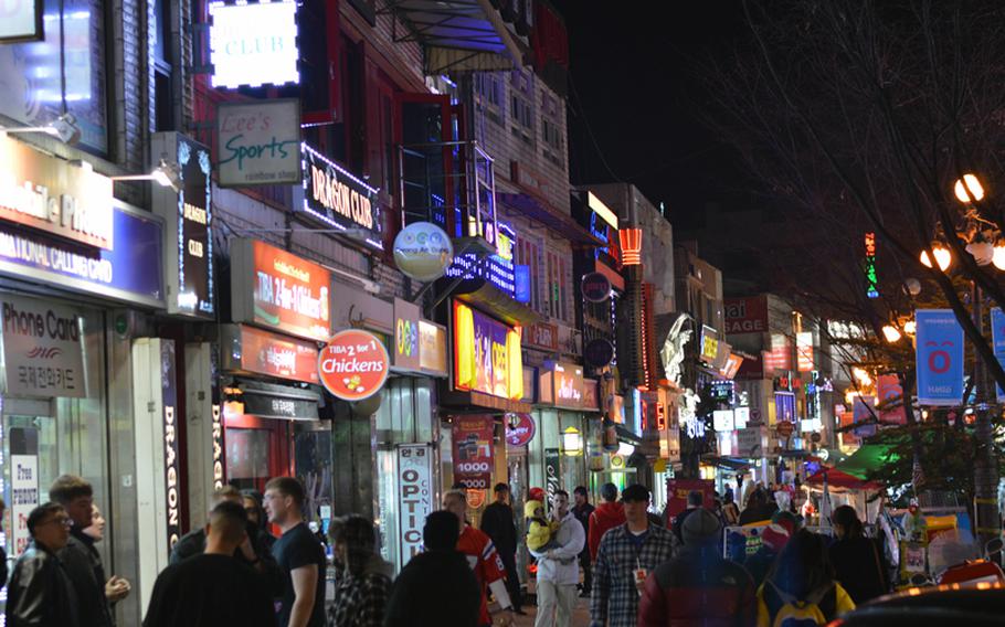U.S. servicemembers and local nationals walk down the main street of the Shinjang Shopping Mall, the entertainment district just outside the front gate of Osan Air Base in South Korea that is home to numerous shops, restaurants and bars on March 16, 2013.