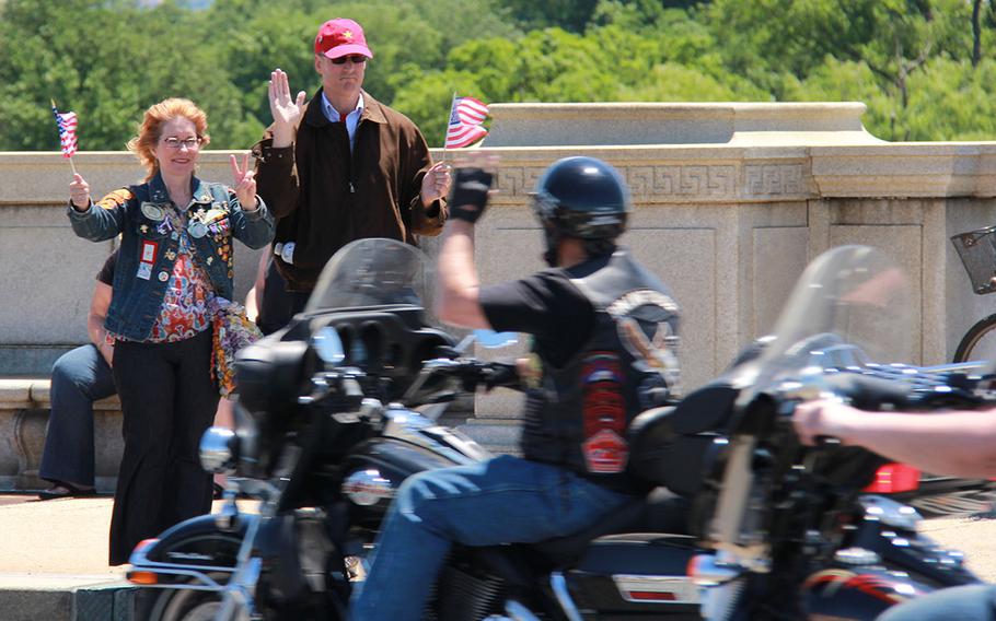 Rolling Thunder supporters wave at demonstrators riding across the Memorial Bridge in Washington DC on May 26, 2013.