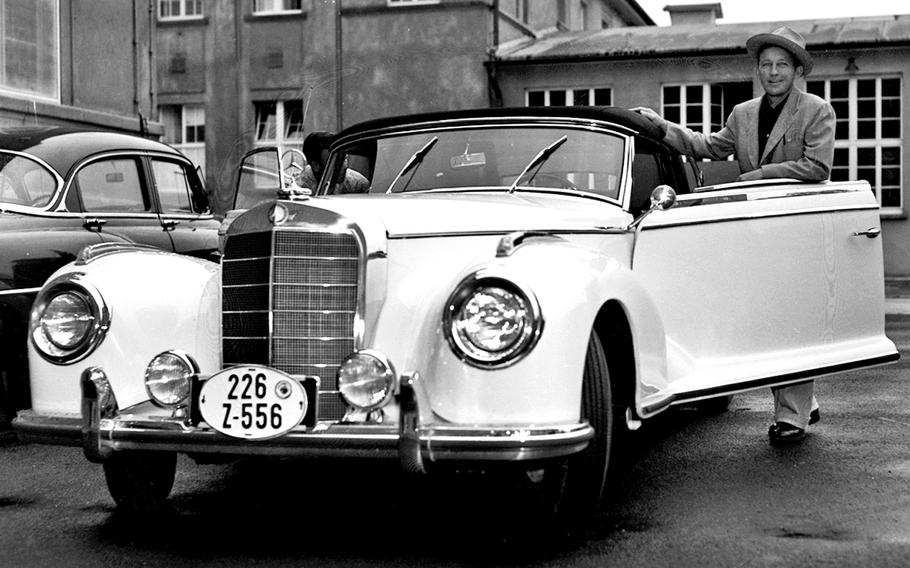 Bing Crosby poses with his new Mercedes in the Stars and Stripes parking lot in August, 1953. Crosby picked up the car in Stuttgart and visited Stripes on the way to Frankfurt, where he played some golf.