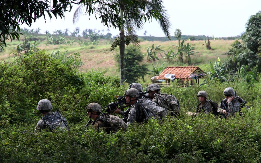 Paratroopers of the 82nd Airborne Division hunker down before a mock assault on a row of abandoned buildings, June 18, 2013. The UN peacekeeping scenario was part of the Garuda Shield exercise going on in Indonesia.