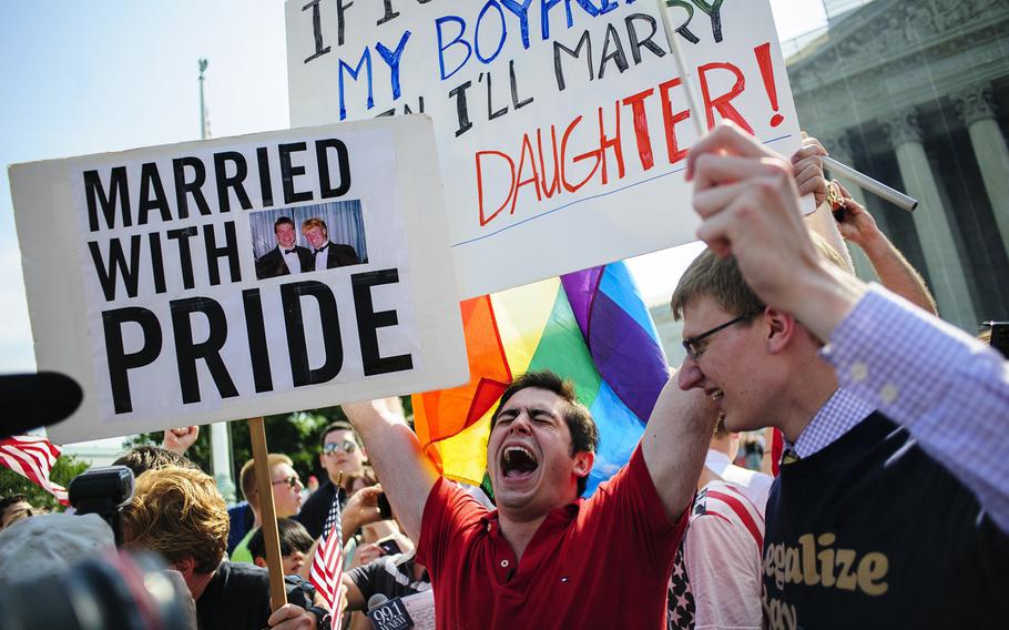 David Baker, 24, center, of Phoenix, Arizona, celebrates outside the Supreme Court after hearing that the Court struck down the Defense of Marriage Act, Wednesday, June 26, 2013, in Washington, D.C.
