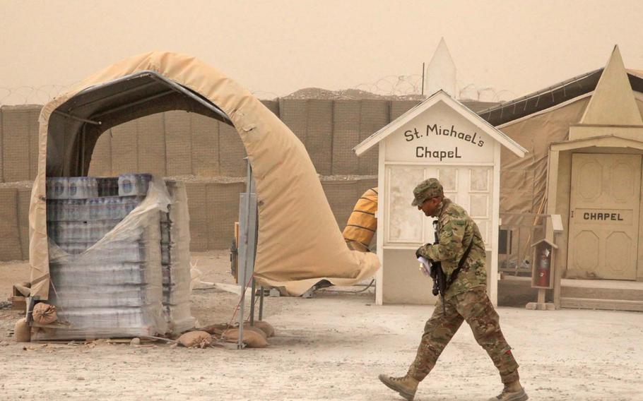 A U.S. Army soldier walks past St. Michael's Chapel during a dust storm at Forward Operating Base Shank, Logar province, Afghanistan, March 19, 2012.