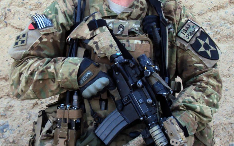 Staff Sgt. Ty M. Carter, with A Troop, 8-1 Cavalry, 2nd Stryker Brigade Combat Team, 2nd Infantry Division, stands guard at a hasty traffic control point in West Kandahar City, Afghanistan, sometime between May and July 2012.