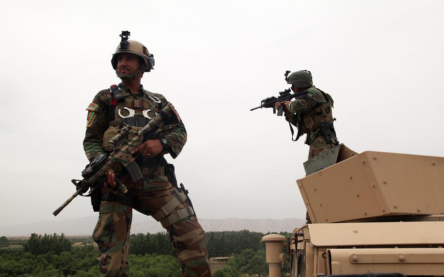 In this file photo from June 3, 2013, 2 Afghan National Army special forces soldiers pull security outside of a combat outpost in Chahar Darreh district, Kunduz province, Afghanistan.