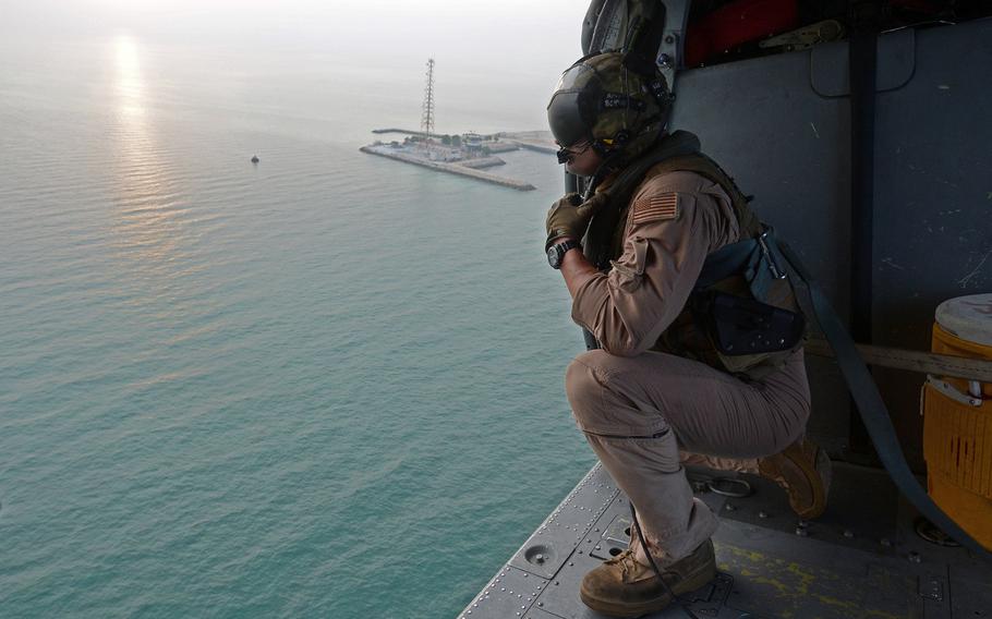 A sailor with Helicopter Sea Combat Squadron 26 looks out an MH-60S Sea Hawk helicopter while on a search and rescue training operation. Attached to Commander, Task Force 53, HSC-26's Det. 1 provides combat logistics and search and rescue capability throughout the U.S. 5th Fleet area of responsibility.