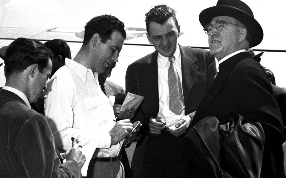 Msgr. Edward J. Flanagan, founder of the famous Boys Town children's home in Nebraska, talks with reporters at the Rhein-Main airport in May, 1948.