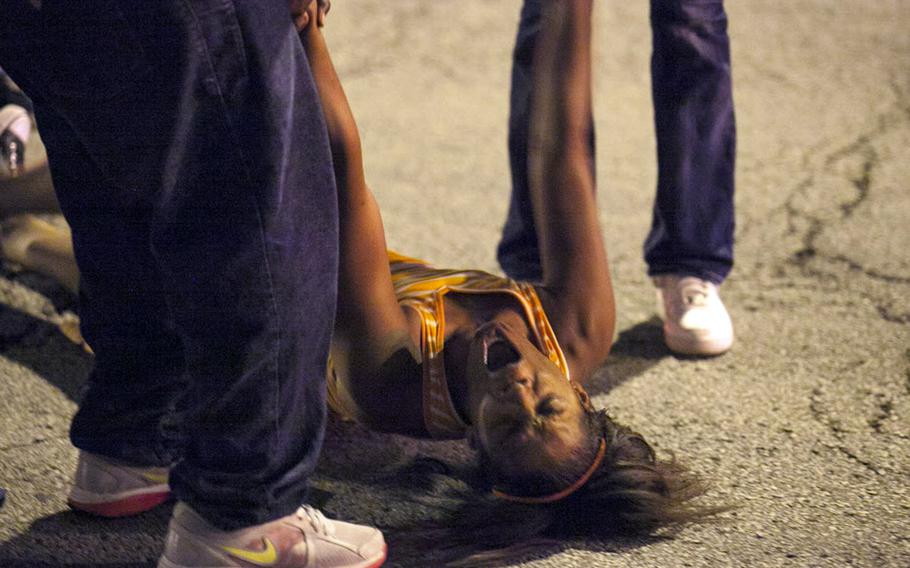 A women becomes emotional Thursday, Sept. 19, 2013, near the scene of a shooting at Cornell Square Park in Chicago's Back of the Yard neighborhood that left multiple victims wounded, including a 3-year-old boy.