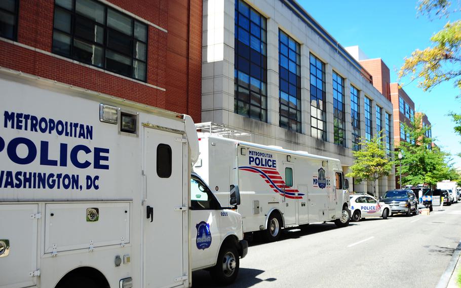 Washington Metropolitan Police Department vehicles are parked near the Naval Sea Systems Command headquarters building at the Washington Navy Yard on Sept. 18, 2013. The Navy awarded a $6.4 million contract to make safety repairs and assessments on whether to keep the building. On Sept. 16, former sailor Aaron Alexis shot and killed 12 people in the building.