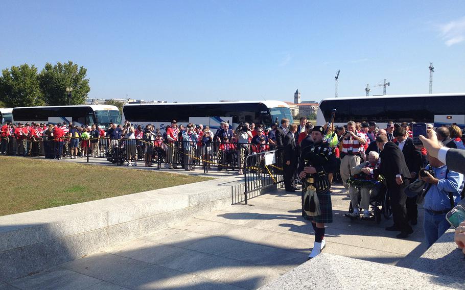 Lead by a bagpiper, veterans enter the WWII memorial in Washington, D.C., on Tuesday.