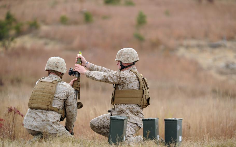 Sgt. Garrett Dennard, an instructor with the Infantry Officer Course at Marine Corps Base Quantico, Va., loads a 60mm mortar round during a demonstration of the new Fire Control Unit sight on Tuesday. In addition to improving accuracy, officials believe the sight will save lives and cut costs over the duration of its use. 