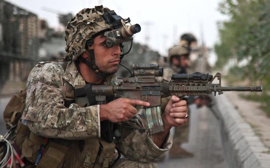 An Afghan security force member provides security during an operation in search of a Taliban facilitator in Dand district, Kandahar province, Afghanistan, May 23, 2013.