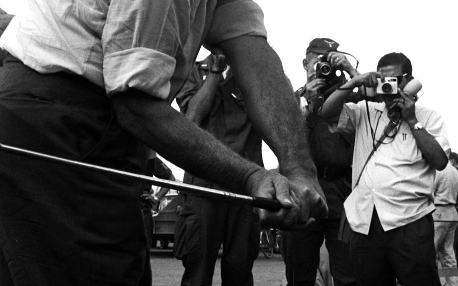 Bob Hope takes a practice swing with his ever-present golf club before his show at Tan Son Nhut Airport.