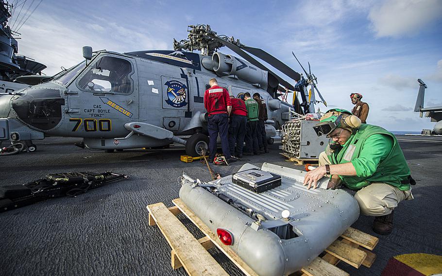 Sailors assigned to the Saberhawks of Helicopter Maritime Strike Squadron remove equipment from an MH-60R Seahawk helicopter aboard the USS George Washington as the carrier was en route to the Philippines on Nov. 13, 2013, to support humanitarian efforts in response to Typhoon Haiyan. 