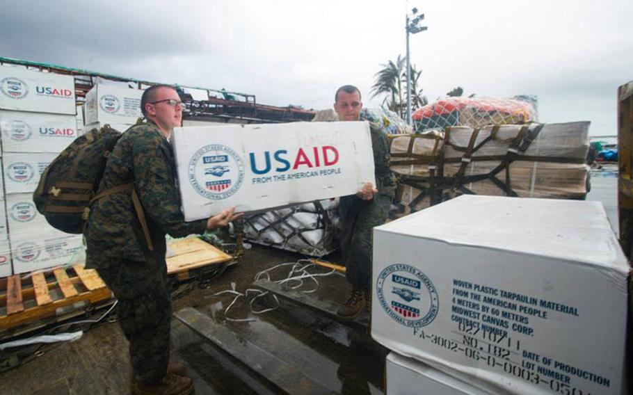 Petty Officer 3rd Class Eric Chiarito, left, from Hyde Park, N.Y., and Marine Sgt. Jonathan Thornton, from Lake Havasu, Ariz., load supplies onto a forklift at Tacloban Air Base in support of Operation Damayan.