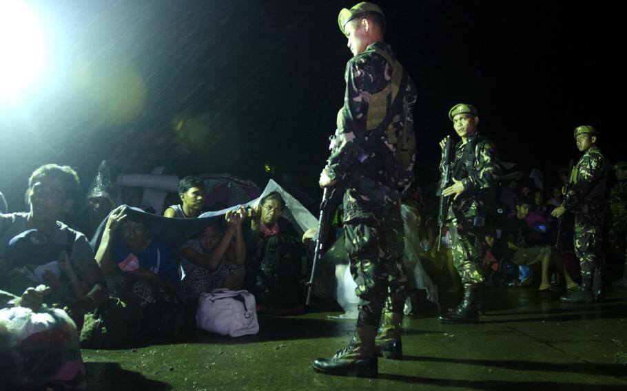 Philippine Army guards maintain order among typhoon victims waiting to board a flight out of Tacloban Airport bound for Villamor Airbase, Manila, Philippines, November 15, 2013.