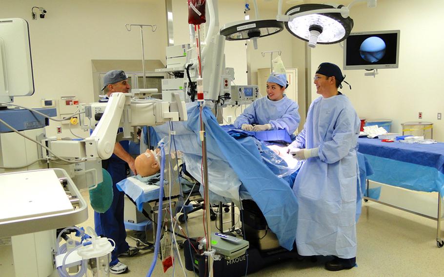 Doctors at the new naval hospital at Camp Pendleton simulate scoping a knee in one of the hospital's operating rooms. The 9 operating room suites at the new facility are equipped with state-of-the-art monitoring capabilities that allow doctors, nurses and medical residents to see how surgeries are progressing on screen without crowding the surgeon. 