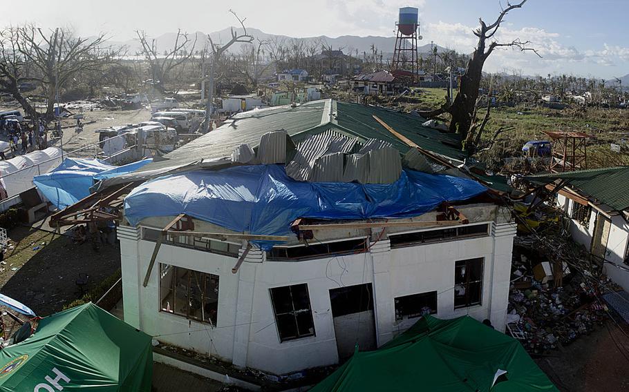 First responders set up a medical treatment area inside a storm-struck building just outside of Tacloban Airport, Tacloban, Philippines, to treat victims injured by Super Typhoon Haiyan.