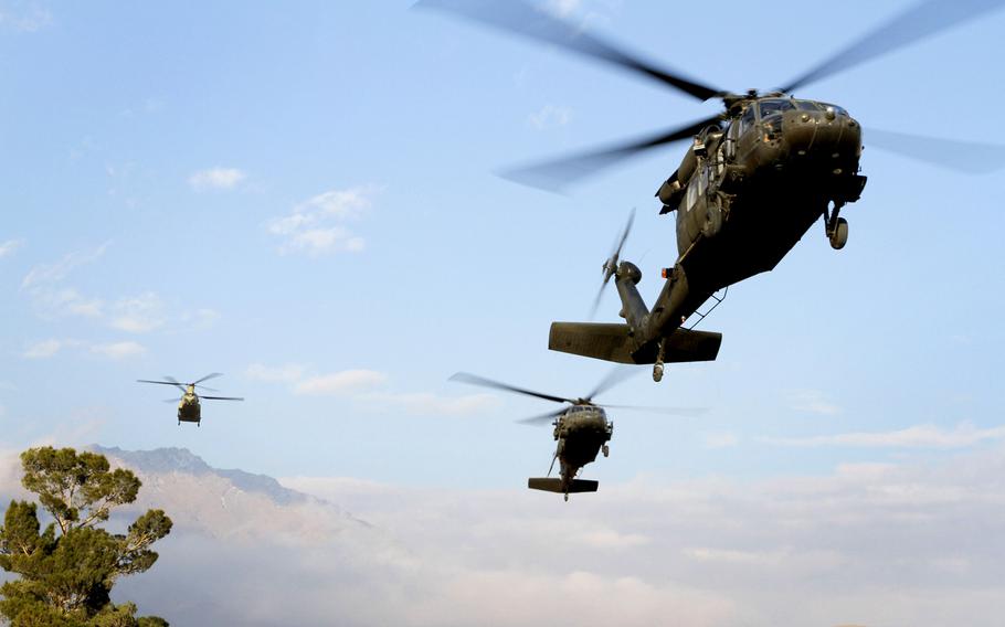 Two U.S. UH-60 Black Hawks and a U.S. CH-47 Chinook prepare to land Nov. 24, 2013, on Camp Commando near Kabul, Afghanistan.