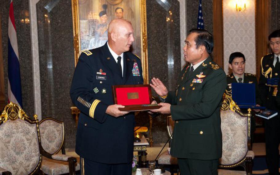 In this file photo from July 20, 2012, U.S. Army Chief of Staff Gen. Raymond T. Odierno, left, exchanges gifts with Thai Army Chief of Staff Gen. Prayuth Chan-ocha during Odierno's visit to Bangkok, Thailand.