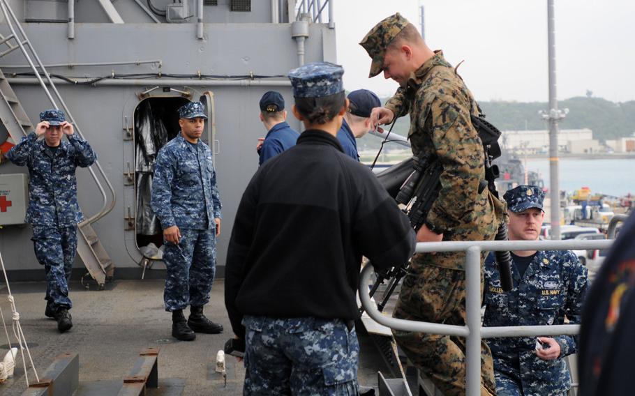 Sailors and Marines board the USS Denver at White Beach Naval Facility, Okinawa, Feb. 4, 2014. Sailors from the Denver and members of the 3rd Marine Division are heading to Thailand in support of the upcoming Exercise Cobra Gold 2014.
                
