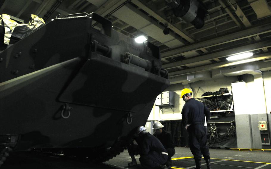 Marines and sailors move light armored vehicles on the USS Denver at White Beach Naval Facility, Okinawa, Feb. 4, 2014. Sailors from the Denver and members of the 3rd Marine Division are heading to Thailand in support of the upcoming Exercise Cobra Gold 2014.
                