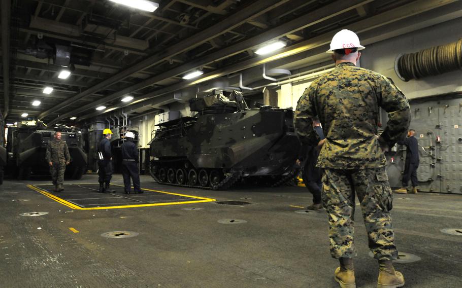 Marines and sailors move light armored vehicles on the USS Denver at White Beach Naval Facility, Okinawa, Feb. 4, 2014. Sailors from the Denver and members of the 3rd Marine Division are heading to Thailand in support of the upcoming Exercise Cobra Gold 2014.
                