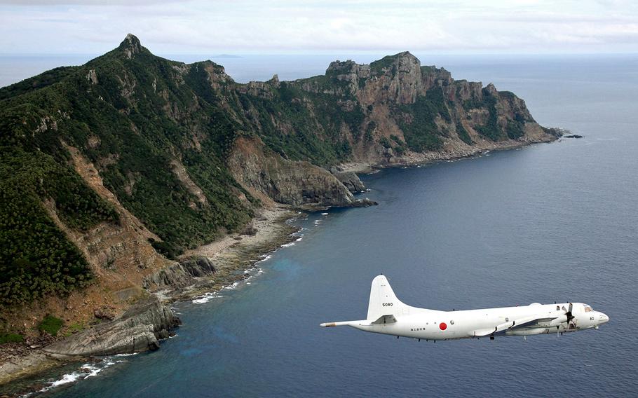A Japan Maritime Self-Defense Force P-3C Orion surveillance plane flies over disputed islands in the East China Sea, called Senkaku in Japan and Diaoyu in China, in this Oct. 13, 2011, file photo.
