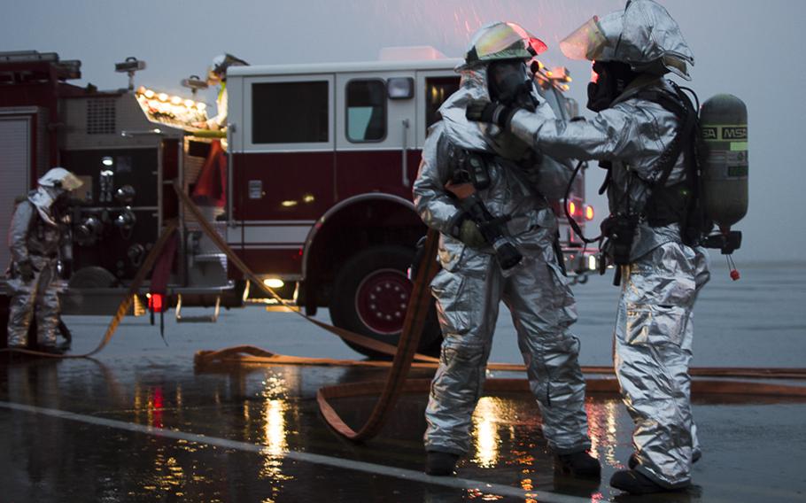 Firemen from the Yokota Fire Department check each others protective equipment before fighting a fire from a simulted Vehicle Borne Improvised Explosive Device during the Samurai Readiness Inspection at Yokota Air Base March 4, 2014.