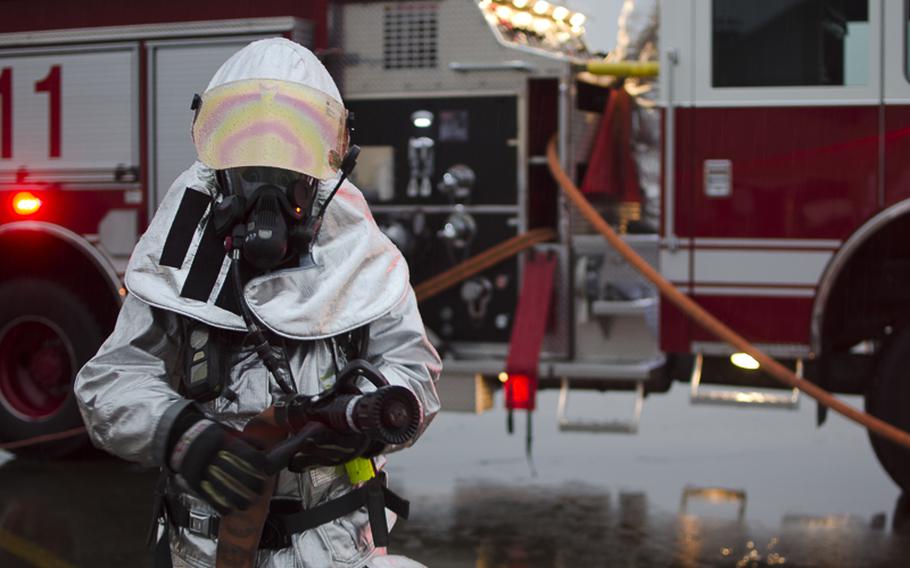 A fireman from the Yokota Fire Department stands in preparation to help fight a fire from a simulted Vehicle Borne Improvised Explosive Device during the Samurai Readiness Inspection at Yokota Air Base March 4, 2014.