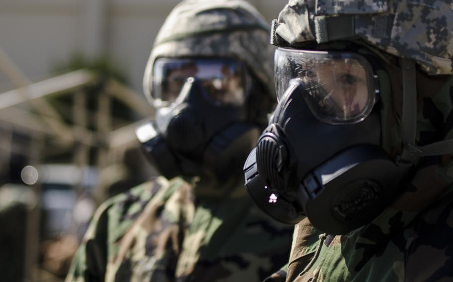 An airman from the 374th Airlift waits for deconamination following a simulated chemical warfare attack at Yokota Air Base during the base's Samurai Readiness Inspection March 5, 2014.