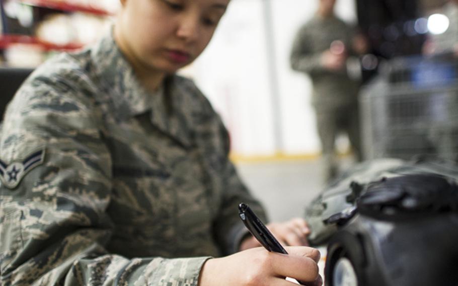 Airman 1st Class Angelika Maldonado-Matlega, 374th Logistics Readiness Suadron individual protective equipment technician, inspects gas masks at Yokota Air Base, Japan, Feb. 28, 2014. 374 LRS Airmen are responsible for all IPE used by Yokota Airmen during exercises and real-world contingencies. 