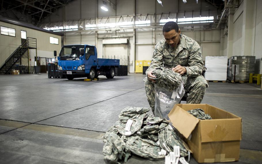 Senior Airman Ronald Sloane, 374th Logistics Readiness Squadron individual protective equipment technician, inspects helmet covers in preperation for Yokota's upcoming Samurai Readiness Inspection at Yokota Air Base, Japan, Feb. 28, 2014. 374 LRS Airmen are responsible for all IPE used by Yokota Airmen during exercises and real-world contingencies. 