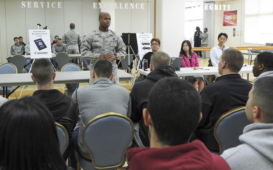 Senior Airman Alvin Porter, customs immigration inspector with the 374th Force Support Squadron briefs simulated non-combatant evacuees during a Samurai Readiness Inspection Mar. 3, 2014, at the Taiyo Community Center at Yokota Air Base, Japan. As the mobility hub of the Western Pacific, Yokota may be called upon to support regional non-combatant evacuation operations in the event of a crisis. Inspections like this ensure the base's readiness to carry out its mission. 