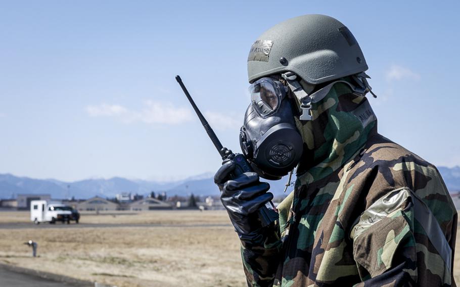Airman 1st Class Brandon Miller, 374th Civil Engineer Squadron uses a radio wearing his mission-oriented protective posture gear at Yokota Air Base, Japan, March 6, 2014. Yokota is continuing their week-long Samurai Readiness Inspection, where they are being tested to perform under the challenging scenarios such as a chemical warfare attack. 