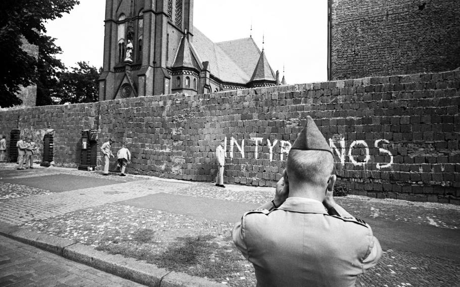 A West Point cadet poses for a photo in front of the Berlin Wall at the Church of Reconciliation in 1964.