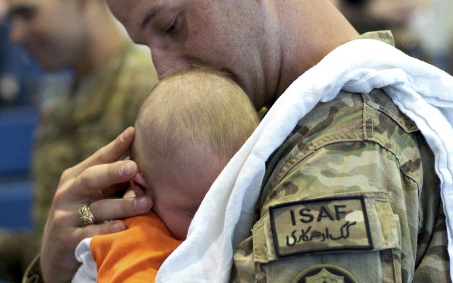 Capt. Riley Redus holds his son, Caleb John, for the first time after returning from a nine-month deployment to Afghanistan with the 2nd Cavalry Regiment, Monday, April 7, 2014.