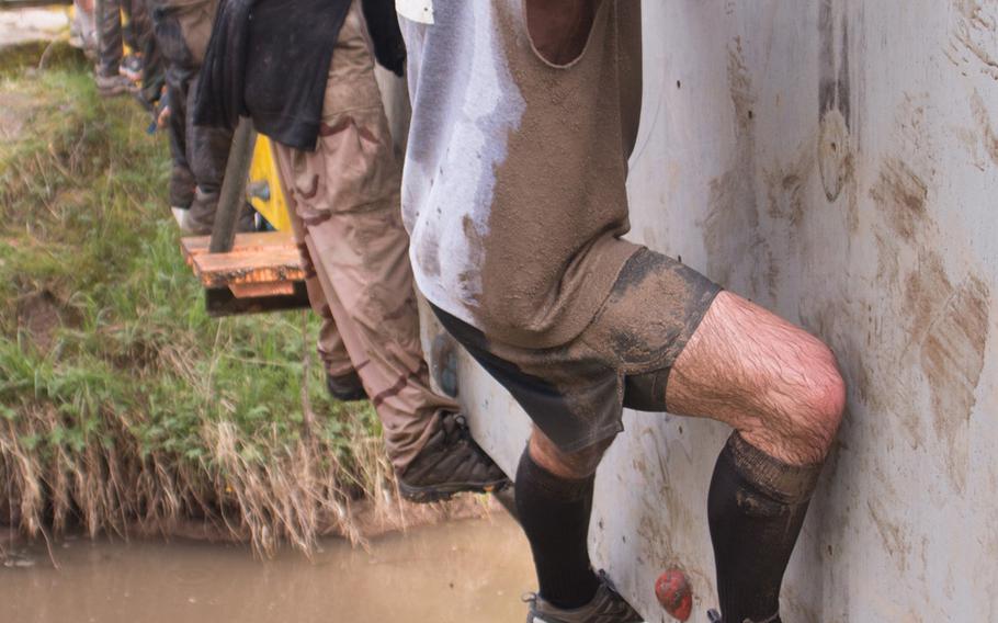 Participants at the Grafenwöhr Rugged Terrain Obstacle Course shimmy across a bridge over a 10-foot drop into muddy water, April 12, 2014. 