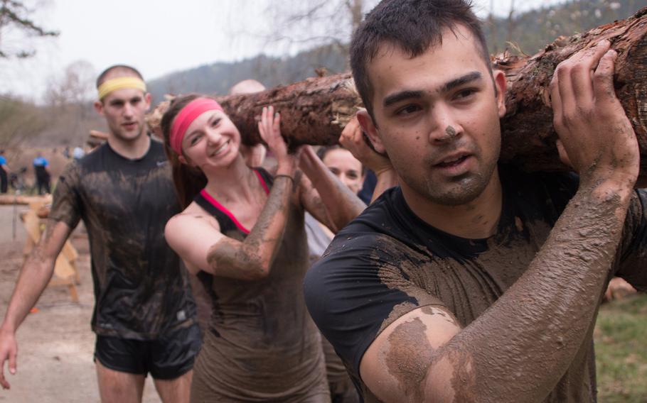 Teammates pick up freshly-sawed logs for a lengthy run as part of the Grafenwöhr Rugged Terrain Obstacle Course on April 12, 2014. 