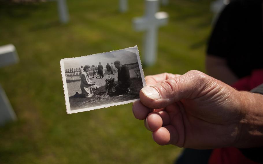 Ernest Schrasser, who cares for the grave of Staff Sgt. Raymond Marz at the Netherlands American Cemetery in Margraten, Netherlands, shows a picture of his parents undertaking the same task. Schrasser's father adopted the grave in 1946, and the job of caring for it has been in the family ever since. All 8,301 American World War II graves at the cemetery have been similarly adopted by Dutch families.