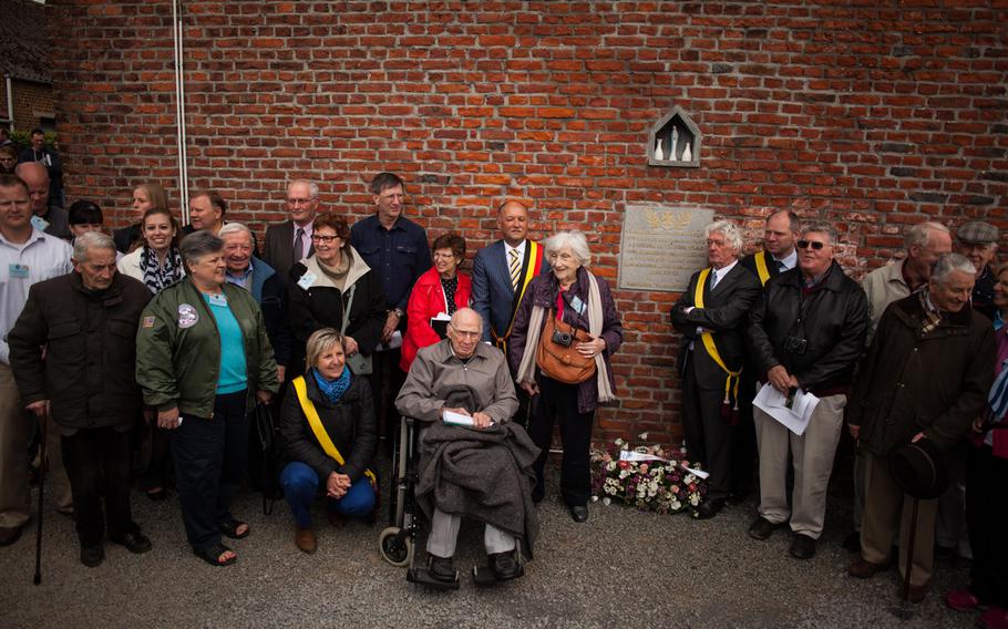 Troy Hollar, seated center, poses for photos with Belgian officials and the relatives of some of his former crew mates from World War II in Fouleng, Belgium, on Sunday, April 13, 2014. The village, along with U.S. forces from nearby Chievres Air Base, held a memorial ceremony marking the 70th anniversary of a B-17 bomber crash here in which Hollar was involved. Hollar and three other crew members bailed out before the plane, hit by German flak, crashed in a field. 