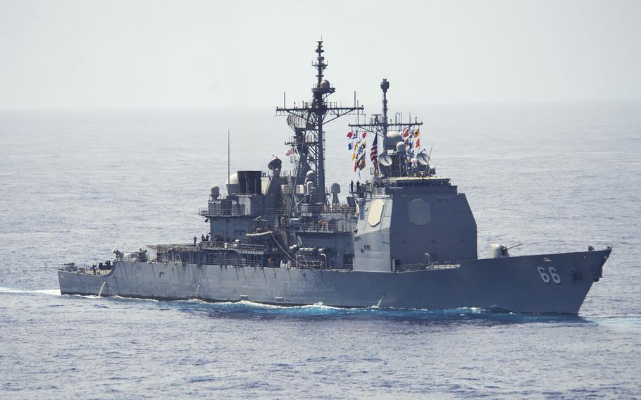 USS Hue City steams astern of the aircraft carrier USS Dwight D. Eisenhower in this June 2013 photo. 